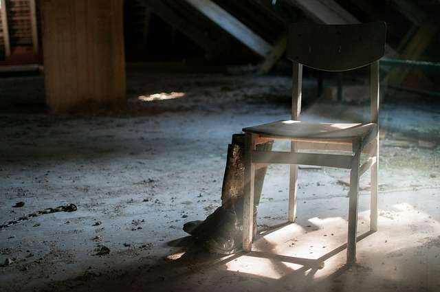 Capire e gestire lo stress, l'ansia e la depressione 5 Sedia vuota in un ambiente abbandonato illuminata da un raggio di luce, simbolo del ritiro emotivo nella depressione