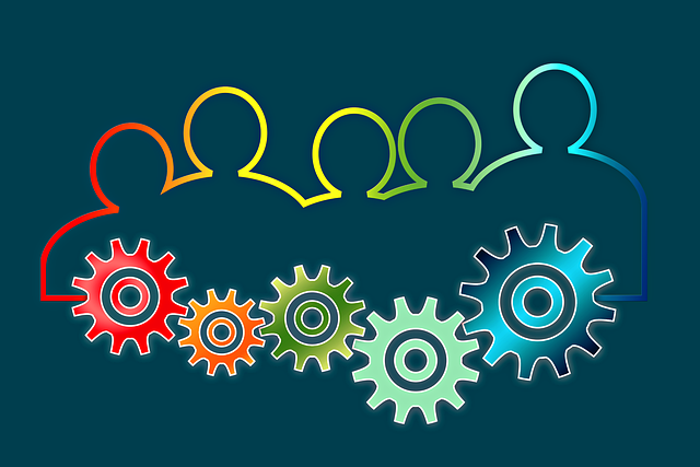 Psicologia del lavoro: coaching, consulenza e performance 7 Sagome umane collegate a una serie di ingranaggi colorati, metafora della dinamica e della gestione dei gruppi di lavoro