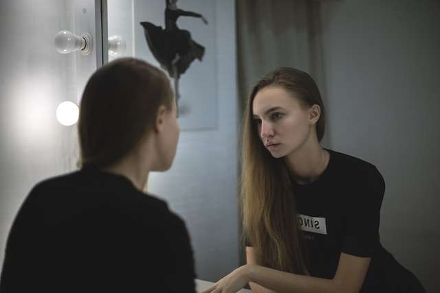 Le dinamiche della comunicazione umana 3 Ragazza che si osserva allo specchio, simbolo del dialogo interiore e della consapevolezza di sé