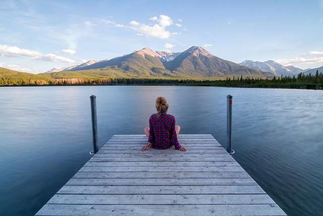 Capire e gestire lo stress, l'ansia e la depressione 7 Donna assorta in contemplazione di un lago calmo con sullo sfondo le montagne